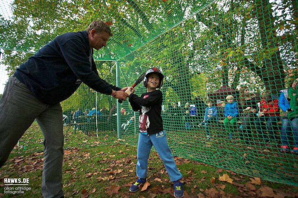 Trainer zeigt einem Kind den richtigen Schwung
